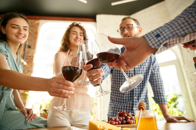 People clinking glasses with wine on the summer terrace of cafe or restaurant.