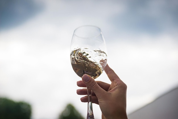 People clinking glasses with wine on the summer terrace of cafe or restaurant