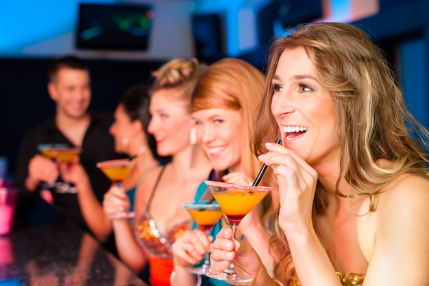 People in club or bar drinking cocktails