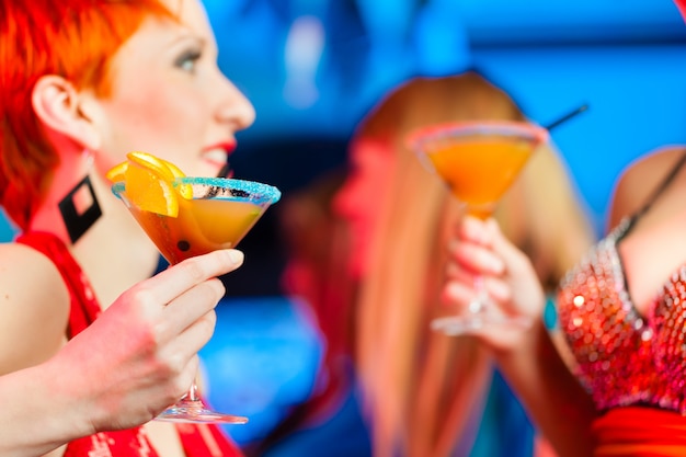 People in club or bar drinking cocktails