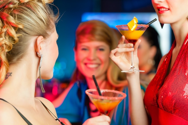 People in club or bar drinking cocktails