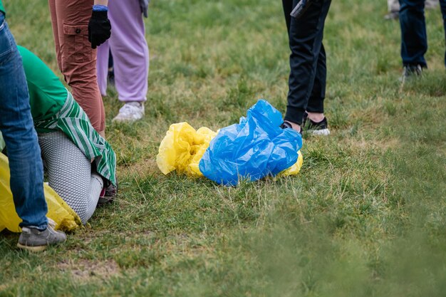 People collect garbage in bags yellow and blue bags in\
nature