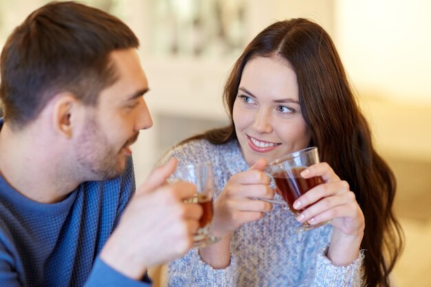 people, communication and dating concept - happy couple drinking tea at cafe or restaurant