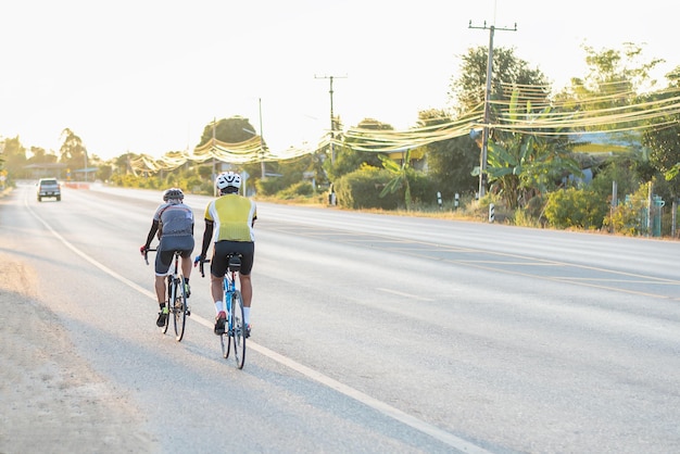 Photo people cycling in the evening during sunset