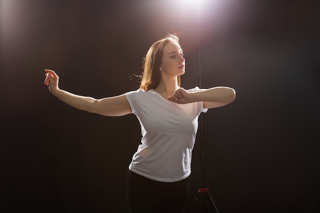 People and dancing concept - Close up of young athletic woman dancing street dance in studio.