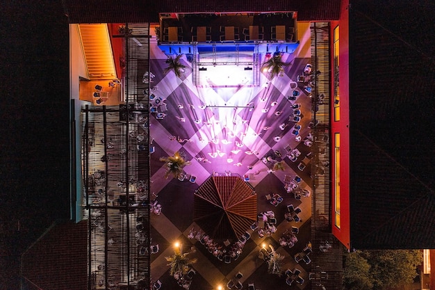 People dancing on the show in a luxury hotel. Aerial view. Night show with people partying with light music.