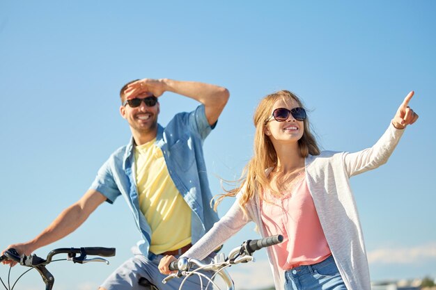 people direction and lifestyle concept happy young couple with bicycles at country in summer