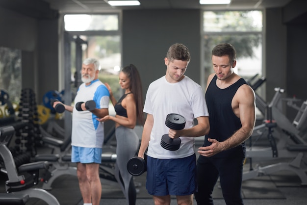 People doing exercises and working out in gym.