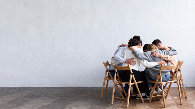 Photo people embraced in a circle at a group therapy session