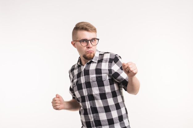 People and emotions concept - Handsome young man in plaid shirt dancing funny over white background