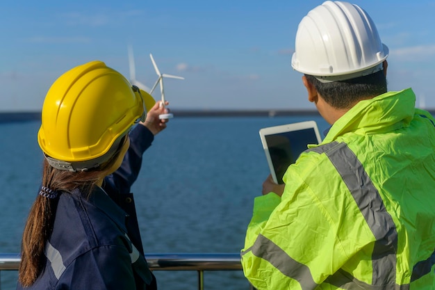 People engineer are wearing a protective helmet on head, using tablet Analytics engineering data.