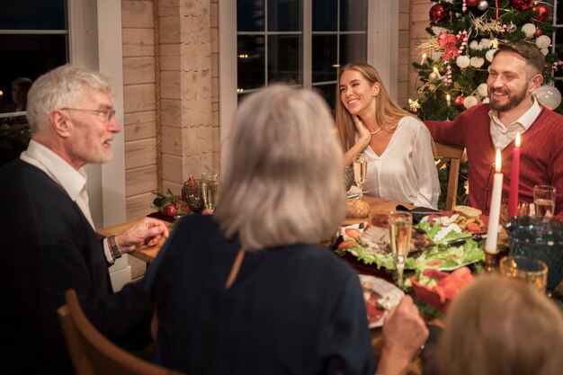 写真 一緒にお祝いのクリスマスディナーを楽しむ人々