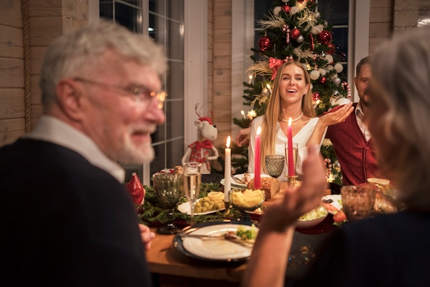 写真 お祝いのクリスマスディナーを楽しむ人々