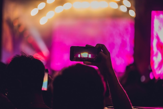 写真 音楽祭でロックコンサートを楽しんだり、携帯電話で写真を撮ったりする人