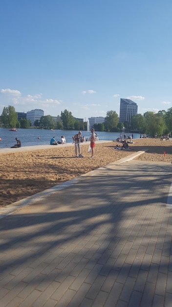 Photo people enjoying at sandy beach against sky