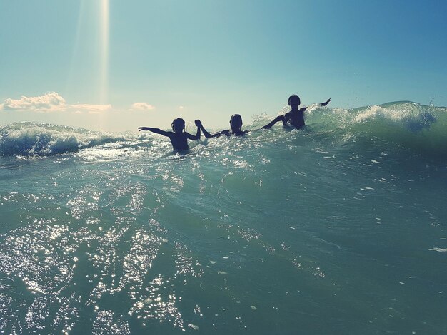 People enjoying in sea against sky