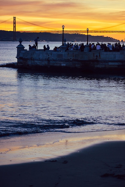 People enjoying the sunset view over the Tagus river in Lisbon