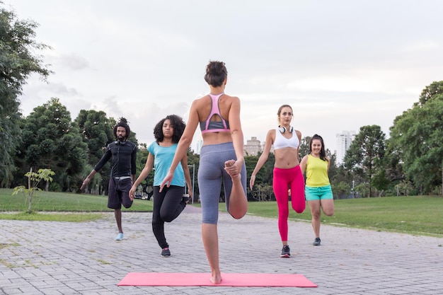 people exercising on footpath against sky at park