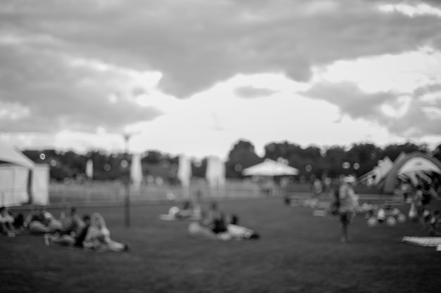 People , Family in a recreation park. Abstract blur people picnic in public park with family or friends, urban leisure lifestyle. Defocused background. Black and white processing