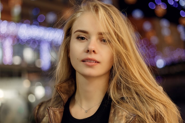 People, fashion, lifestyle and color concept - Young beautiful pretty woman smiling and posing city street night against evening lights bokeh surface