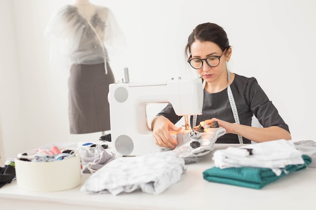 People, fashion and showroom concept - young fashion designer in her showroom.