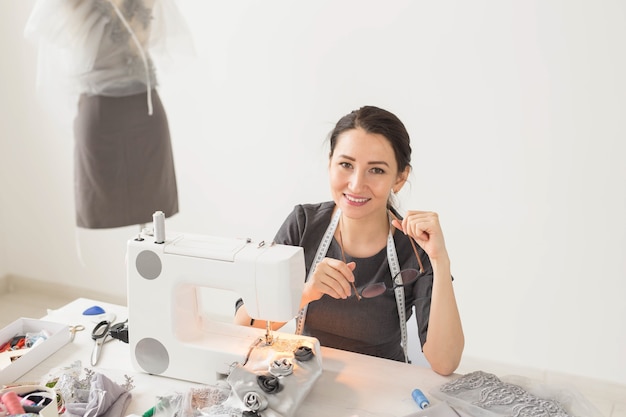 People, fashion and showroom concept - young fashion designer in her showroom.