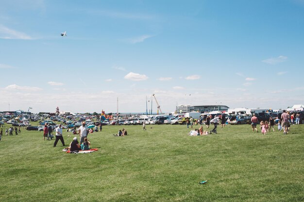 Photo people on field at epsom downs racecourse against sky