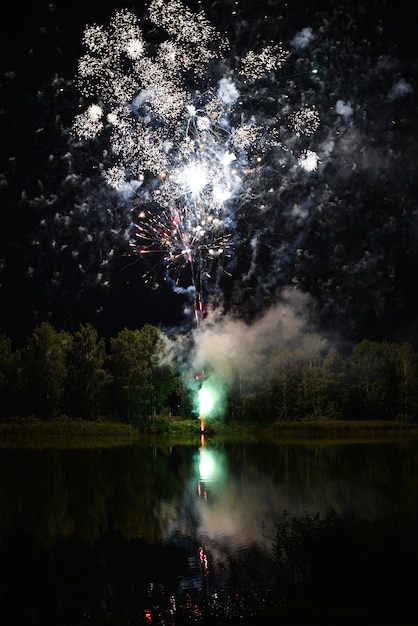 People fire salute near the lake at night