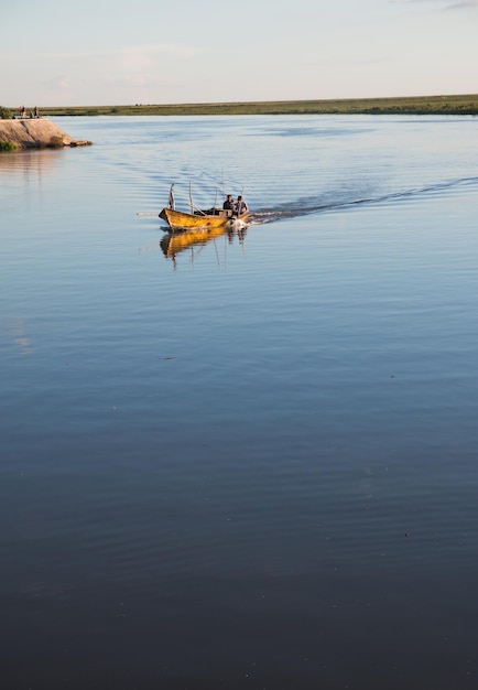 Foto persone in barca da pesca sul lago contro il cielo