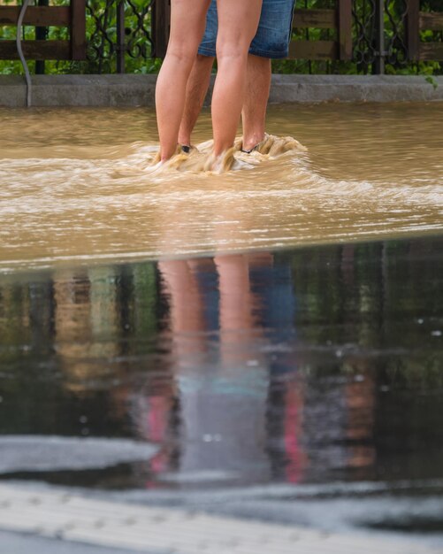 Photo people in floods at city streets after heavy rain severe weather disaster