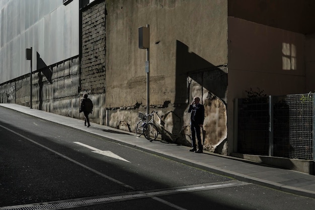 Photo people on footpath by building in city