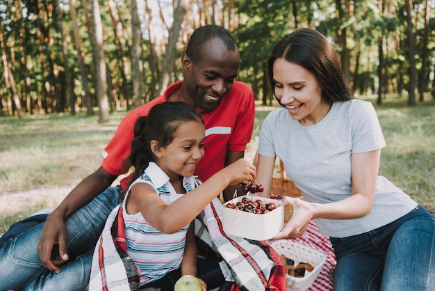 People in the forest eat fruit and rest.