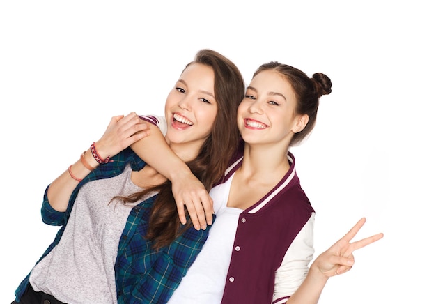 people, friends, teens and friendship concept - happy smiling pretty teenage girls hugging and showing peace hand sign