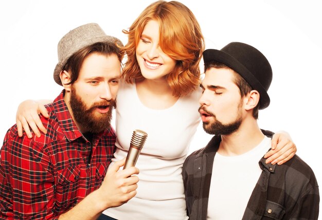 People, friendship  and leisure concept: group of young happy friends  having fun at karaoke, hipster style.Isolated on white.