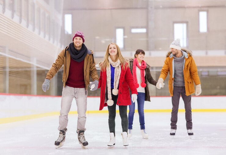 Photo people, friendship, sport and leisure concept - happy friends on skating rink