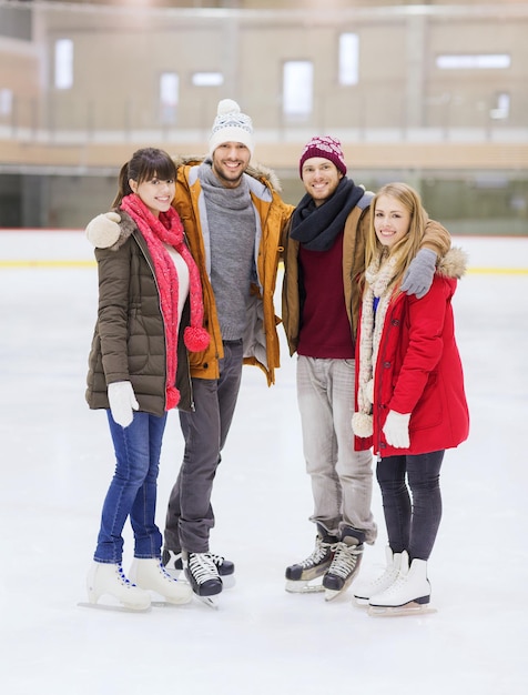 Photo people, friendship, sport and leisure concept - happy friends on skating rink