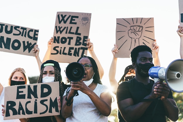 people from different ages and races protest on the street for equal rights - demonstrators wearing face masks during black lives matter fight campaign -