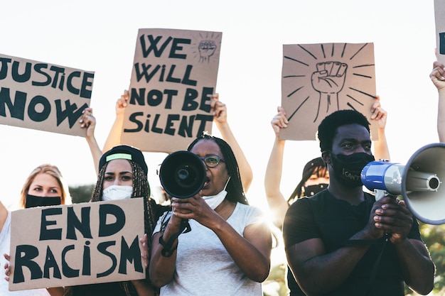 People from different ages and races protest on the street for equal rights - Demonstrators wearing face masks during black lives matter fight campaign -