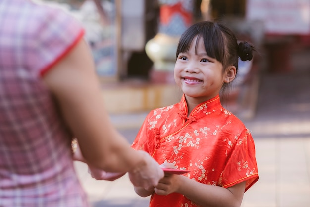 People giving red envelope (ang pao) to child.