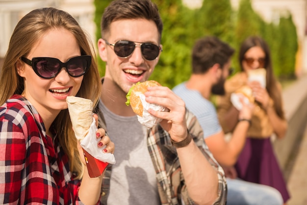 People in glasses are eating fast food.