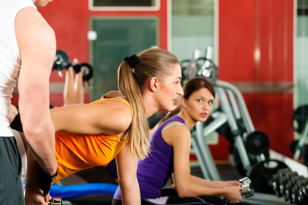 People in gym exercising with weights