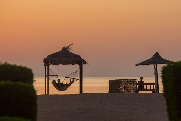 people in hammock and bench waiting for the sunrise at the red sea egypt