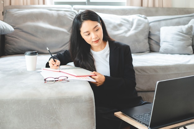 People hand holding a pen for working to write on a book for letter or business document, student education concept to learning by using notebook paper page to note a diary on a office table