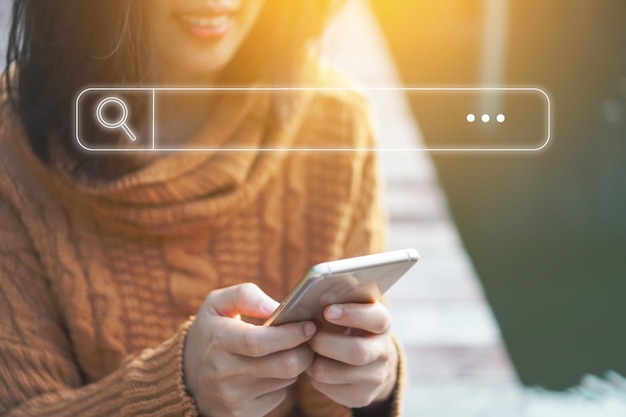 Foto la gente passa facendo uso del telefono cellulare o dello smartphone che cerca le informazioni nel web della società online di internet con l'icona della casella di ricerca.