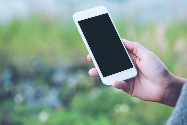 People hand using mockup smart phone at outdoor