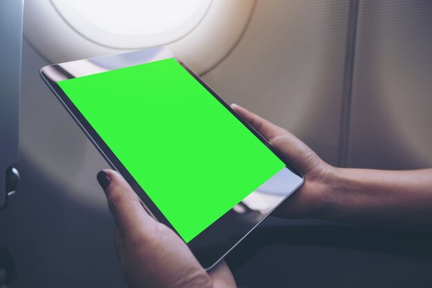 People hand using mockup tablet pc in airplane