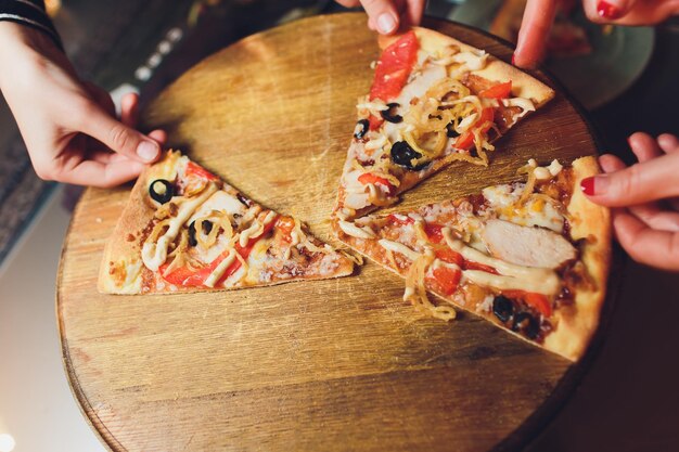 People Hands Taking Slices Of Italian Pizza Italian Pizza and Hands close up over black background