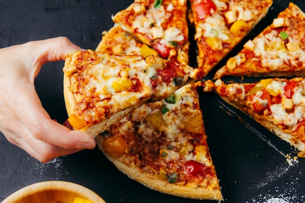 People Hands Taking Slices of Pizza Pizza Margarita and Hands close up over black background