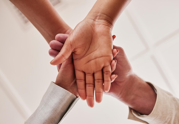 People hands together and unity below in trust for community agreement or teamwork at the office Group piling hand for team collaboration support or coordination for corporate goals in solidarity