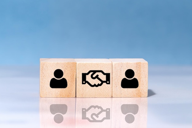 People and handshake Icons on wooden blocks Agreement partnership or deal concept